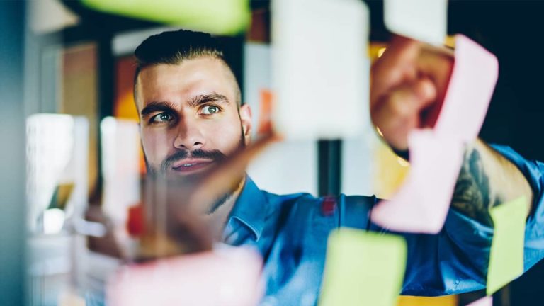 商人在工作场所挂便利贴，正在做一个项目